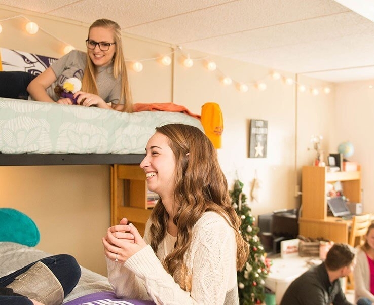Students hanging out together in dorm room.