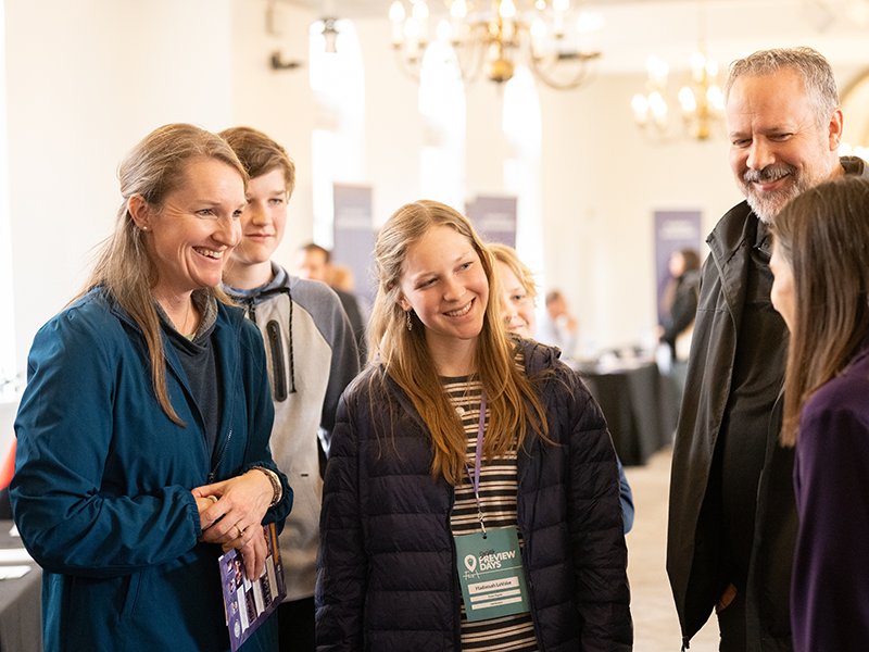 Smiling family talking to staff member.