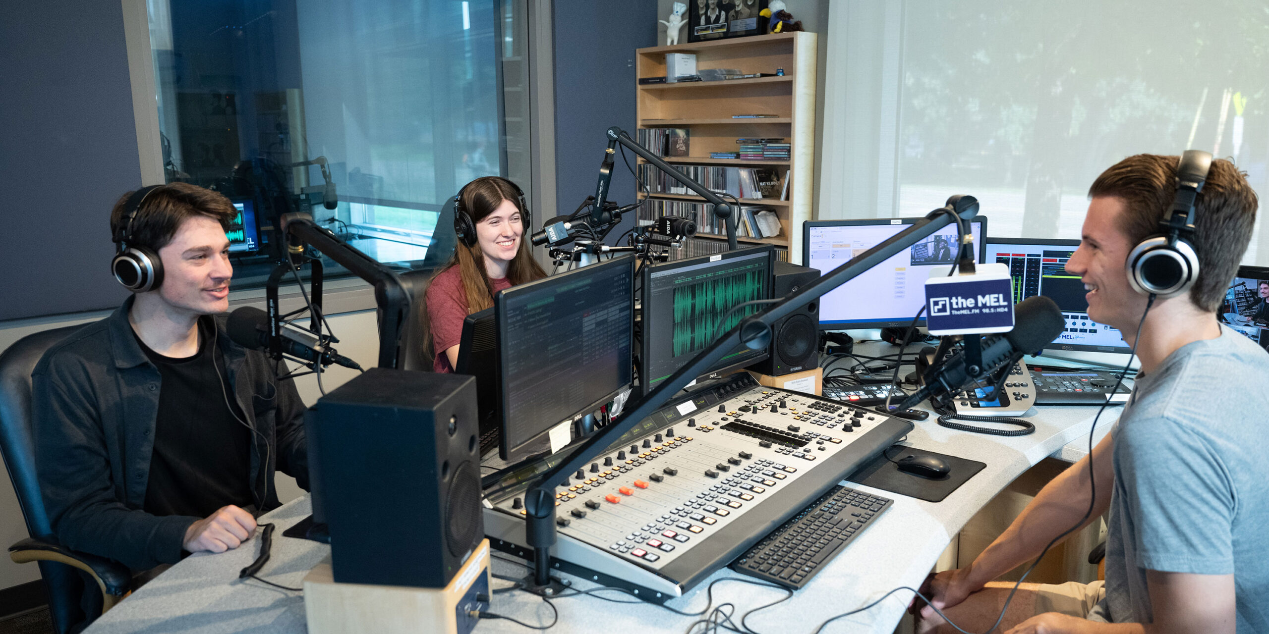 Three students in the radio studio talking on air.