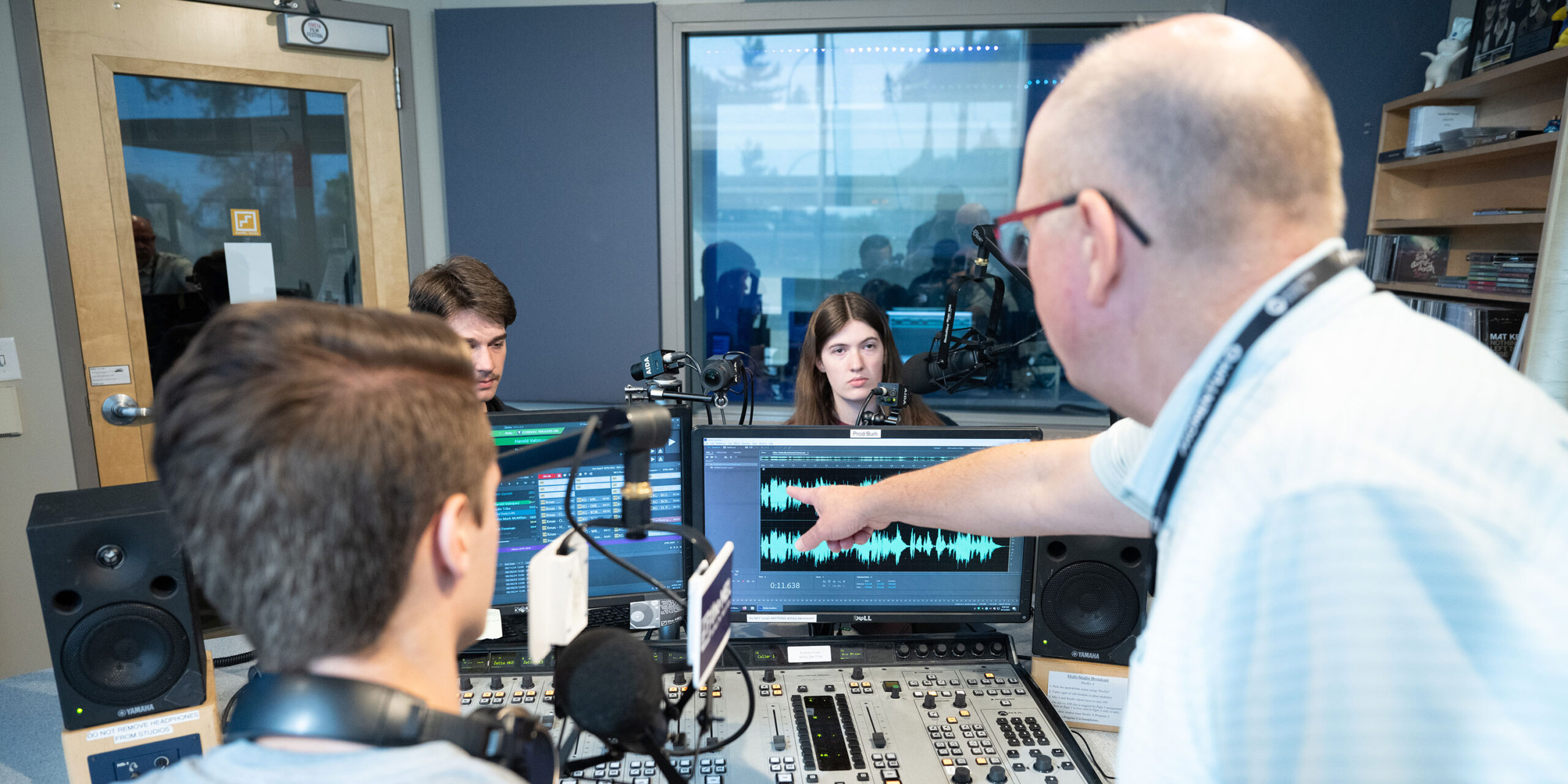 Professor teaching students how to interpret radio waves in the studio.