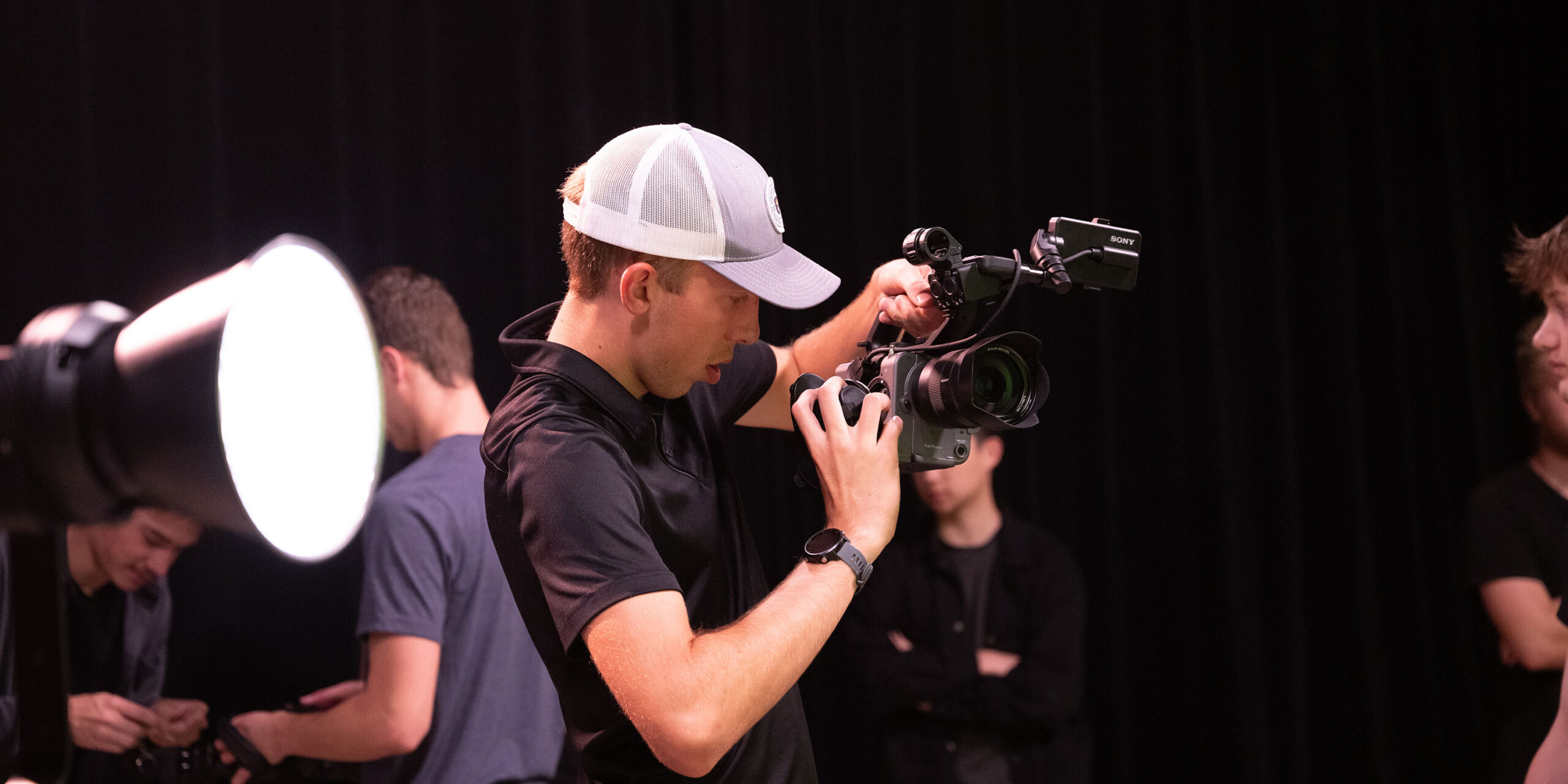 Male student using a camera in the studio.