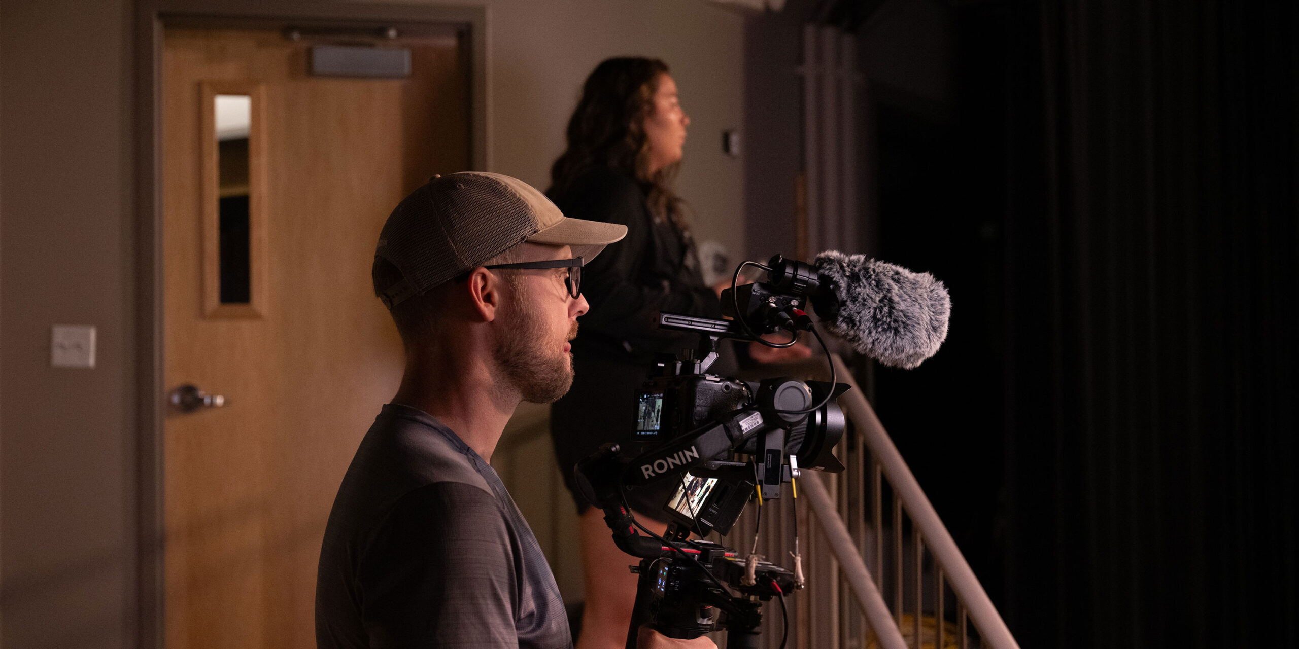 Videographer filming a studio setting.
