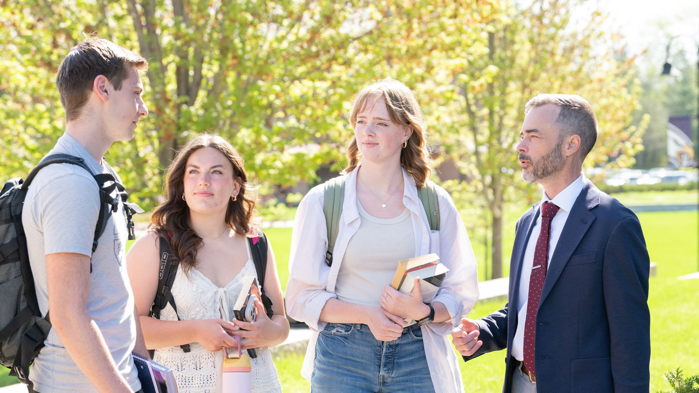 Honors College Students talking with their professor outside in the fall weather.