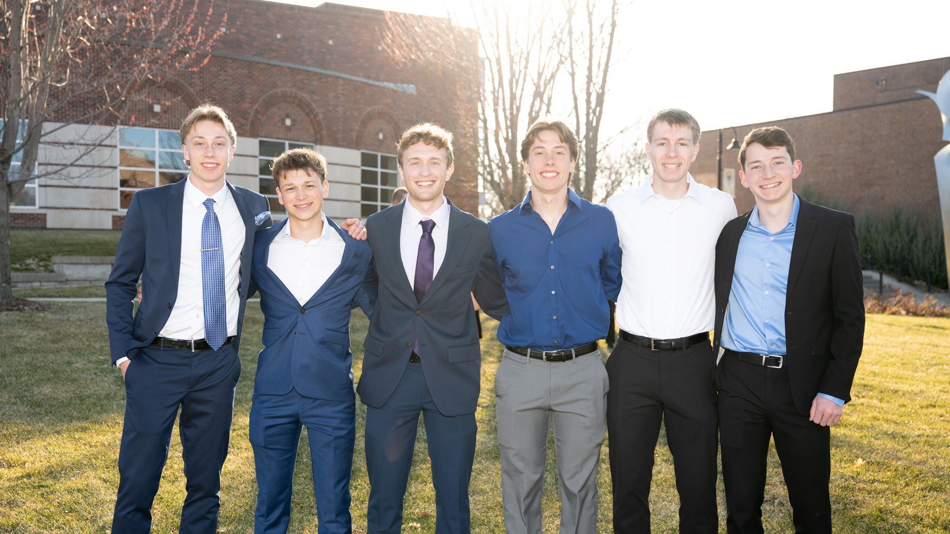Guys posing in front of Totino dressed for Five16.