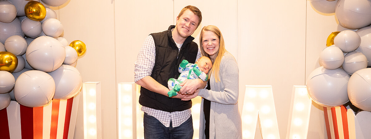 Northwestern couple holding their baby in front of 